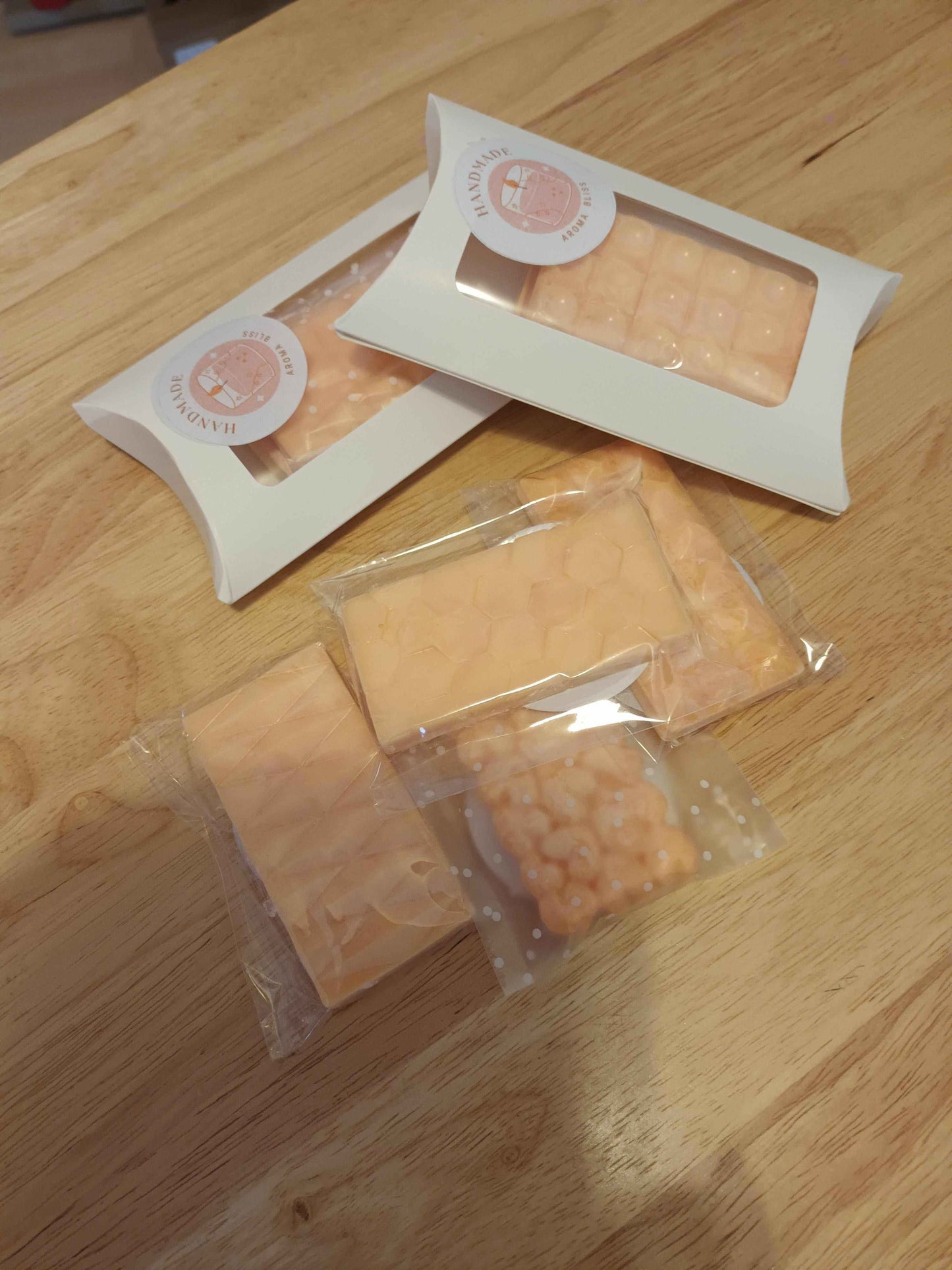 Hand poured natural soy wax melts 2 pack in peach color with floral and geometric designs, packaged in white boxes and plastic wrap.